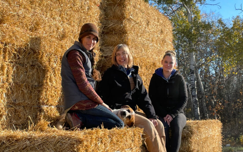 Adagio team sitting bales of hay outside.